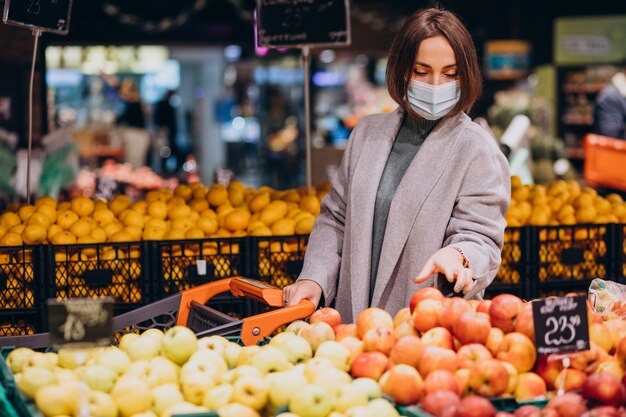 Женщина в маске для лица и покупки в продуктовом магазине