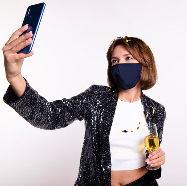 Woman wearing face mask taking a selfie