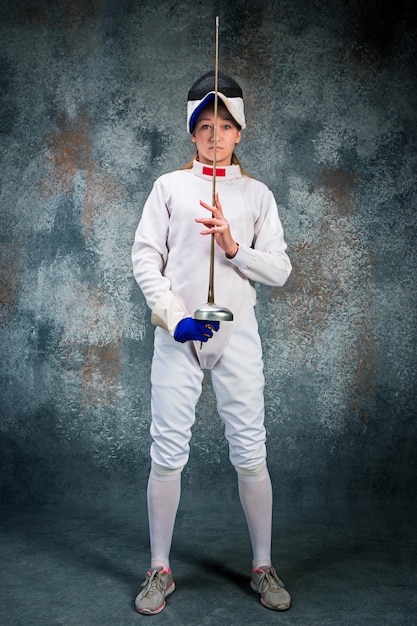 Free photo the woman wearing fencing suit with sword