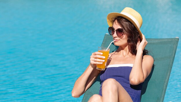 Woman wearing hat laying on sunbed