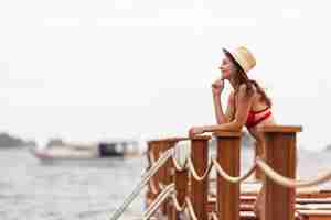 Foto gratuita cappello da portare della donna che esamina mare