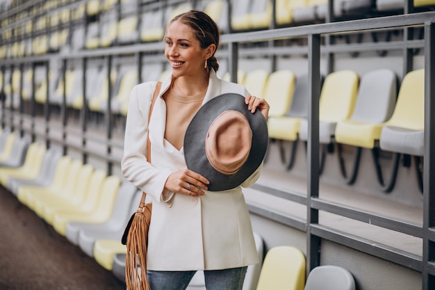 Free photo woman wearing hat and using phone outside the street