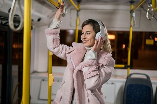 Woman wearing headphones in bus