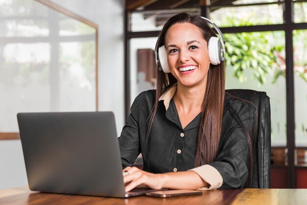 Woman wearing headphones and looking at the camera