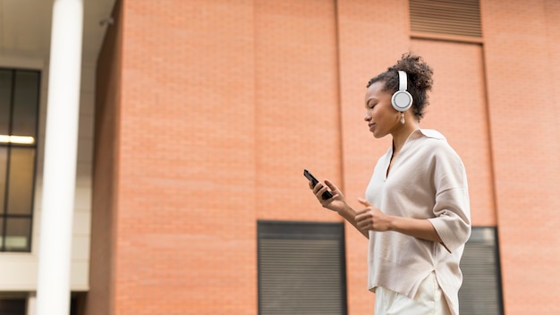 Free photo woman wearing headphones outdoors