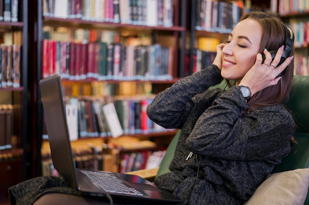 Woman wearing headphones smiling with eyes closed