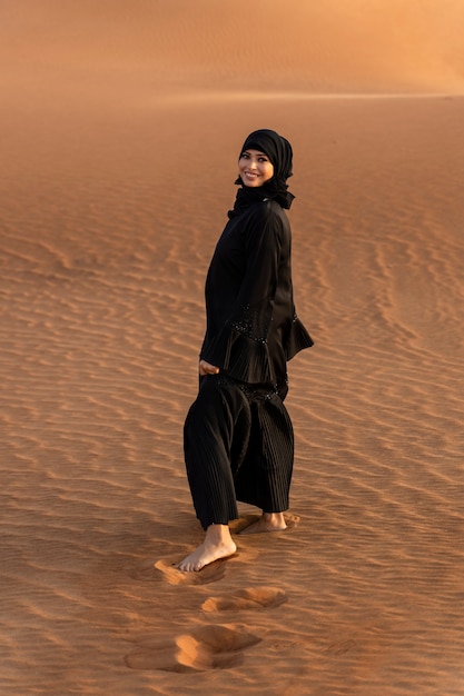 Free photo woman wearing hijab in the desert