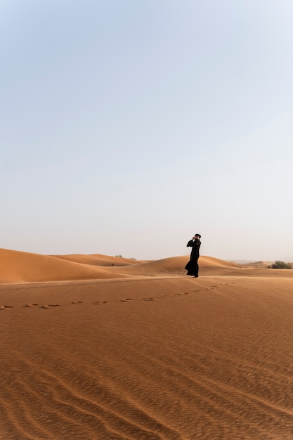 Foto gratuita donna che indossa l'hijab nel deserto