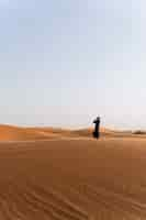 Free photo woman wearing hijab in the desert