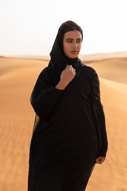 砂漠でヒジャーブを着ている女性
