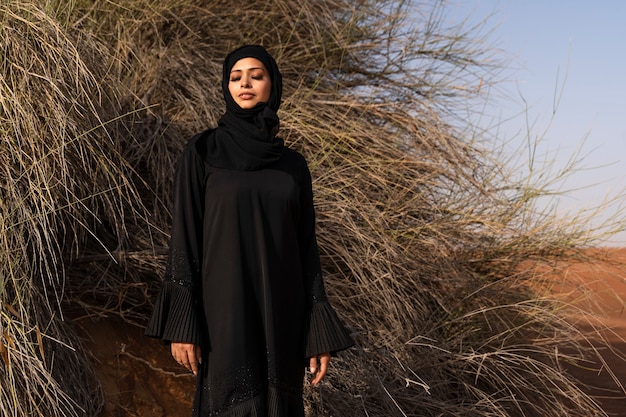 砂漠でヒジャーブを着ている女性