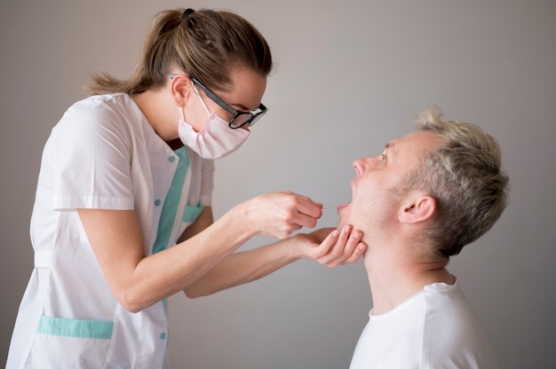 Woman wearing a mask test a man for viruses