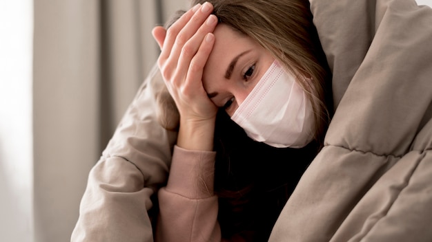 Foto gratuita donna che indossa una maschera medica al chiuso