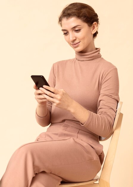 携帯電話を使用してモノクロの服を着ている女性