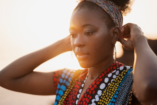 ビーチの夕暮れ時にネイティブアフリカの服を着た女性