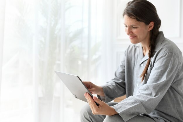 Woman wearing pajamas in a video call on a tablet