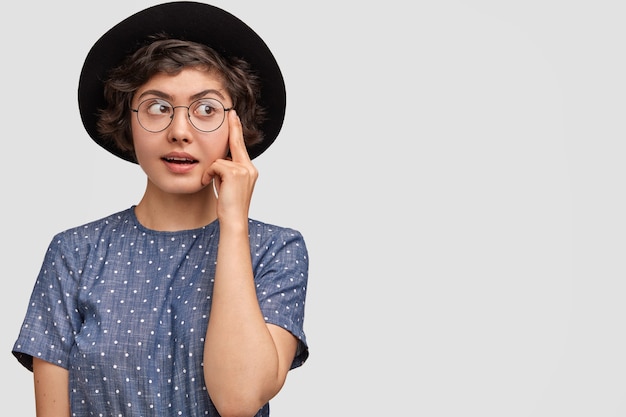 Woman wearing polka dot blouse and big hat