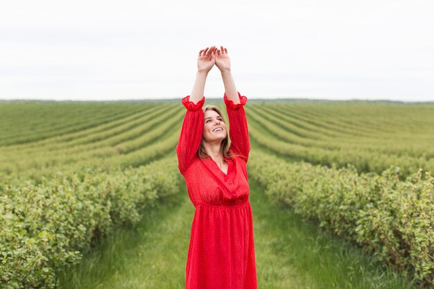 Woman wearing red dress in field