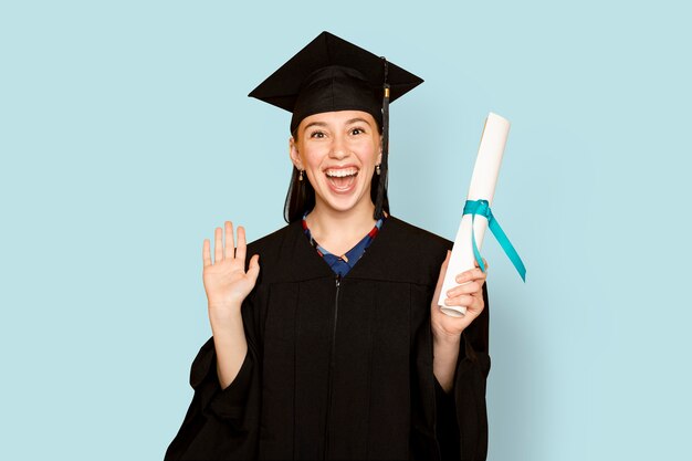 Woman wearing regalia holding her degree for graduation