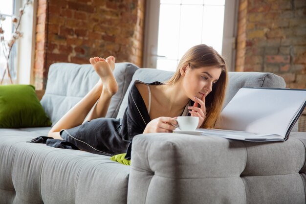 自宅で毎日のスキンケアをしているシルクのローブを着た女性。