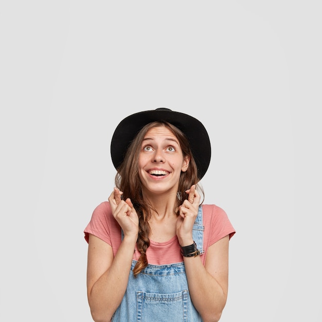 Woman wearing stylish hat and overalls