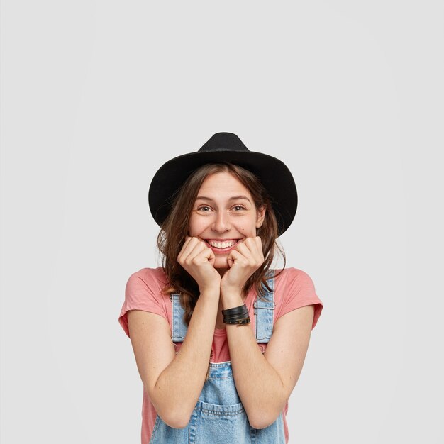 Woman wearing stylish hat and overalls