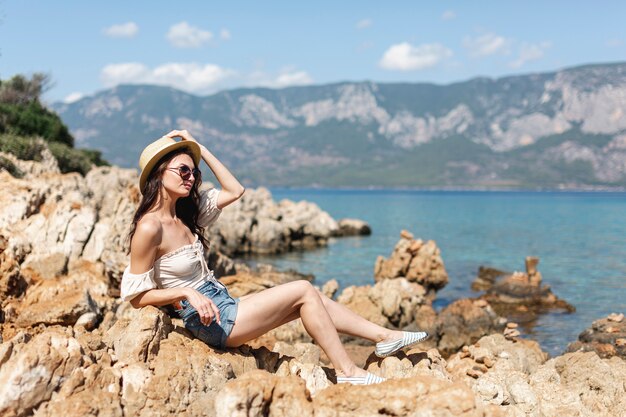 Woman wearing sunglasses standing on rocks