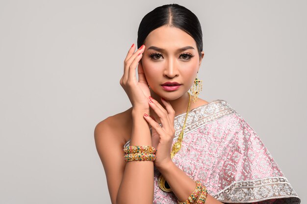 woman wearing Thai clothes and hands touching the head.