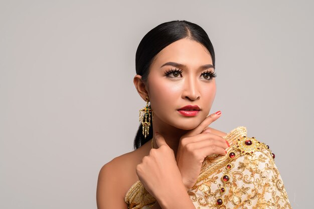 woman wearing Thai clothes and hands touching her face