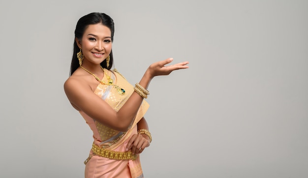 Женщина в тайском платье, которое сделало символ руки
