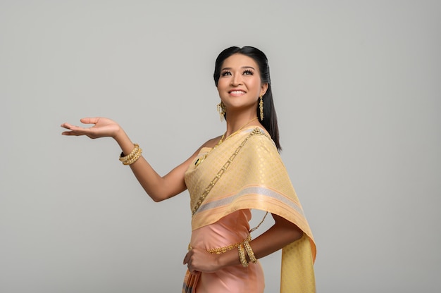 Woman wearing Thai dress that made a hand symbol