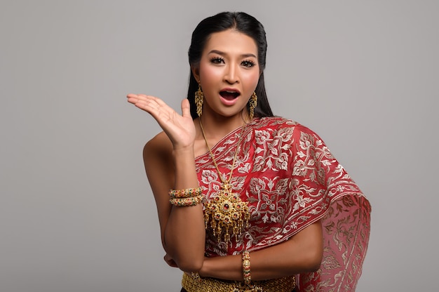 Free photo woman wearing thai dress that made a hand symbol