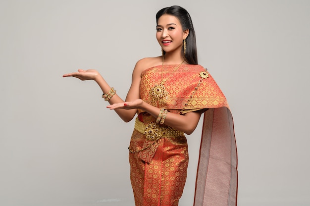 Woman wearing Thai dress that made a hand symbol