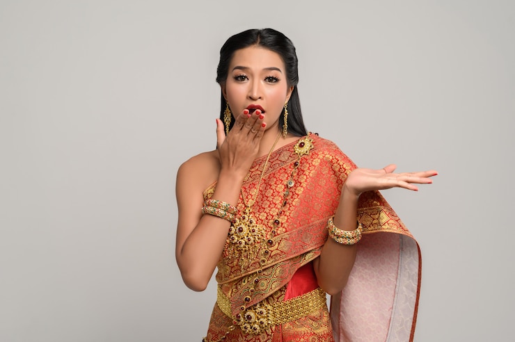 無料Photo 手のシンボルを作ったタイのドレスを着ている女性