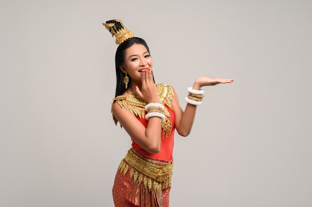 Woman wearing Thai dress that made a hand symbol