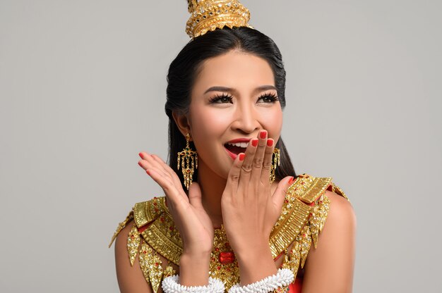 Woman wearing Thai dress that made a hand symbol