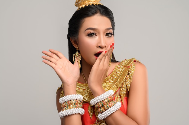 Woman wearing Thai dress that made a hand symbol