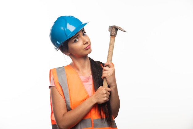 Woman wearing in vest and helmet holding hammer 