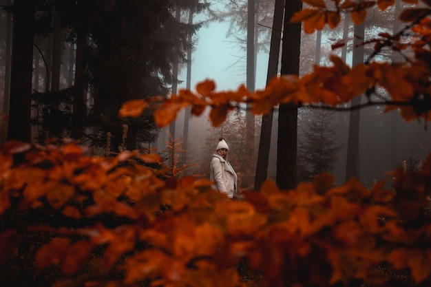 Woman wearing white jacket in forest