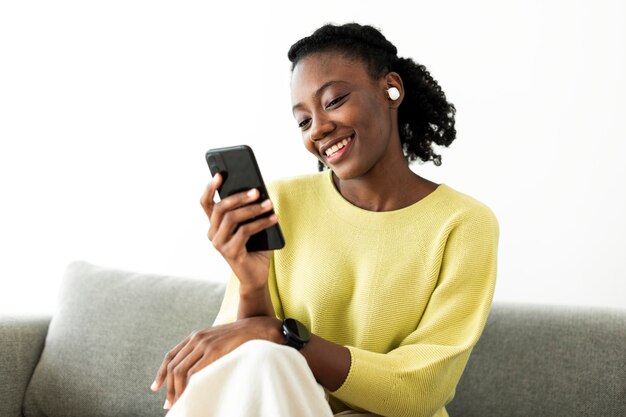 Woman wearing wireless earbuds and using a mobile phone