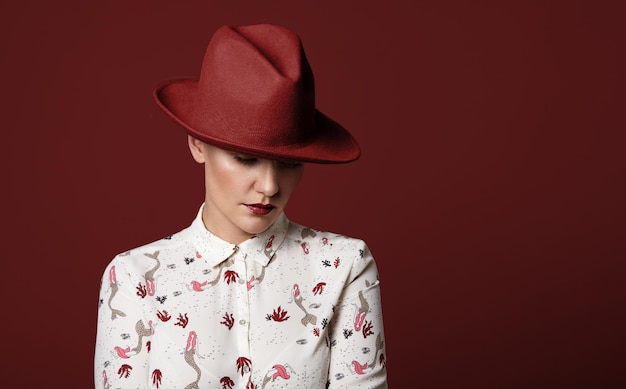 Free photo woman wears a red hat on a red background