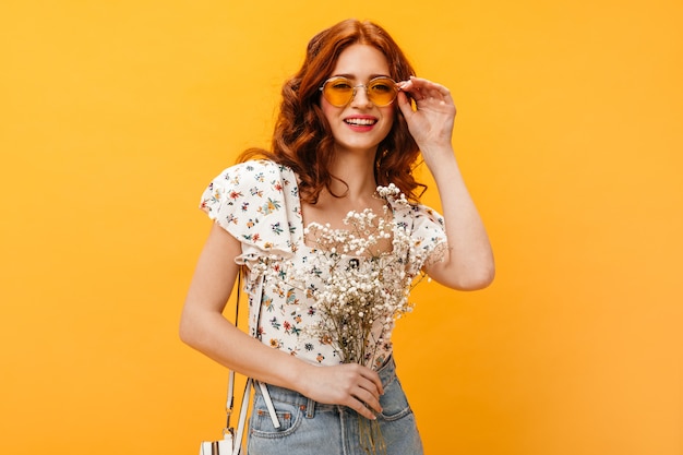 Woman wears sunglasses. pretty woman smiling and posing with bouquet of white flowers.