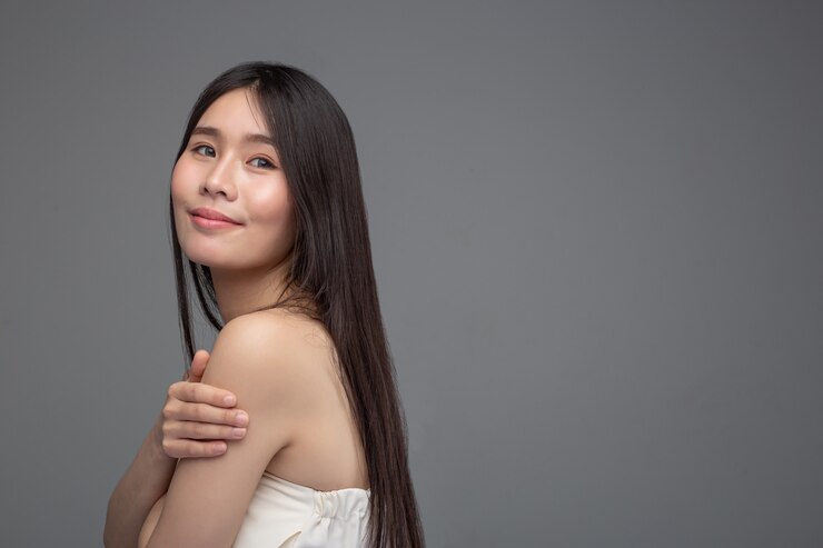 無料Photo 女性は白いストラップレスのドレスと腕にハンドルをつけています。