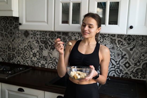 Woman weating healthy meal in the kitchen