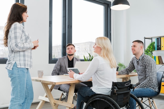 Woman in wheelchair attending meeting in the office