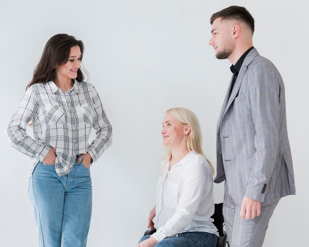 車椅子の同僚と会話する女性