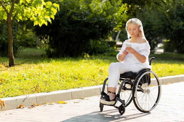 Free photo woman in wheelchair listening to music outside