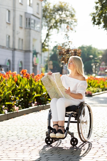 Woman in wheelchair looking at map outside