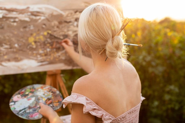 Woman in wheelchair painting outdoors