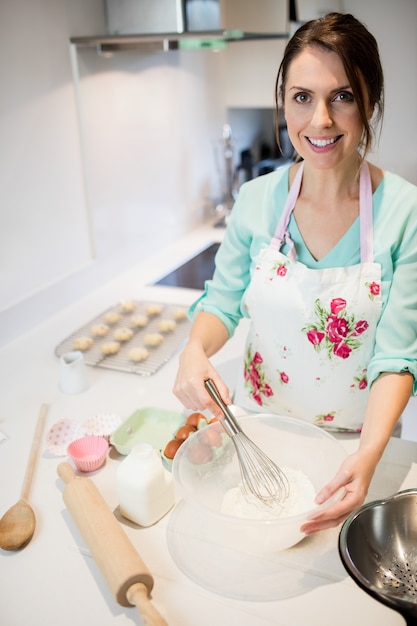 Woman whisking flour in bowl